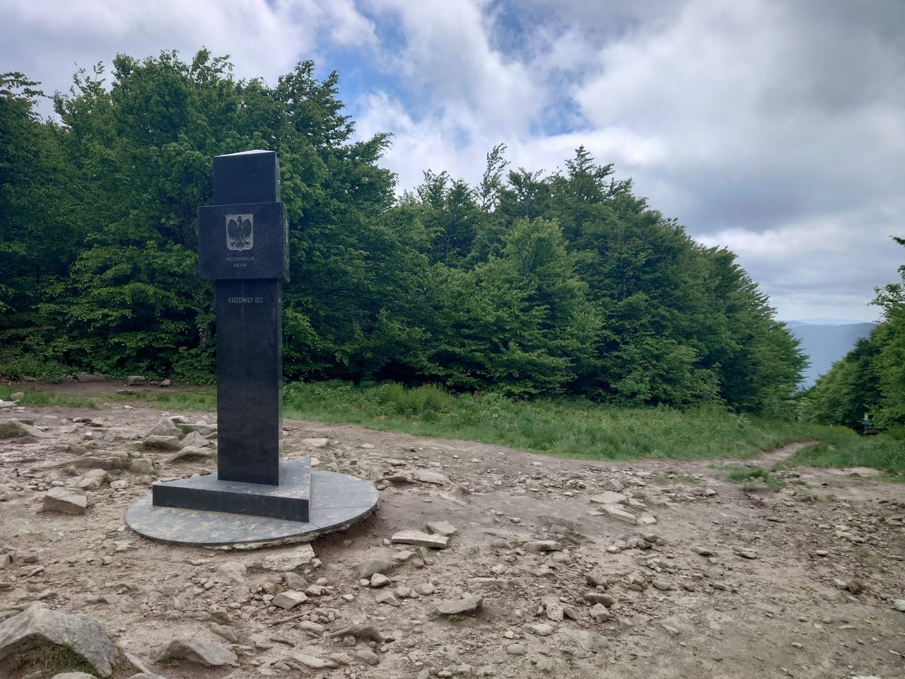 Kamienny obelisk z nazwą Krzemieniec na leśnym trójstyku granic