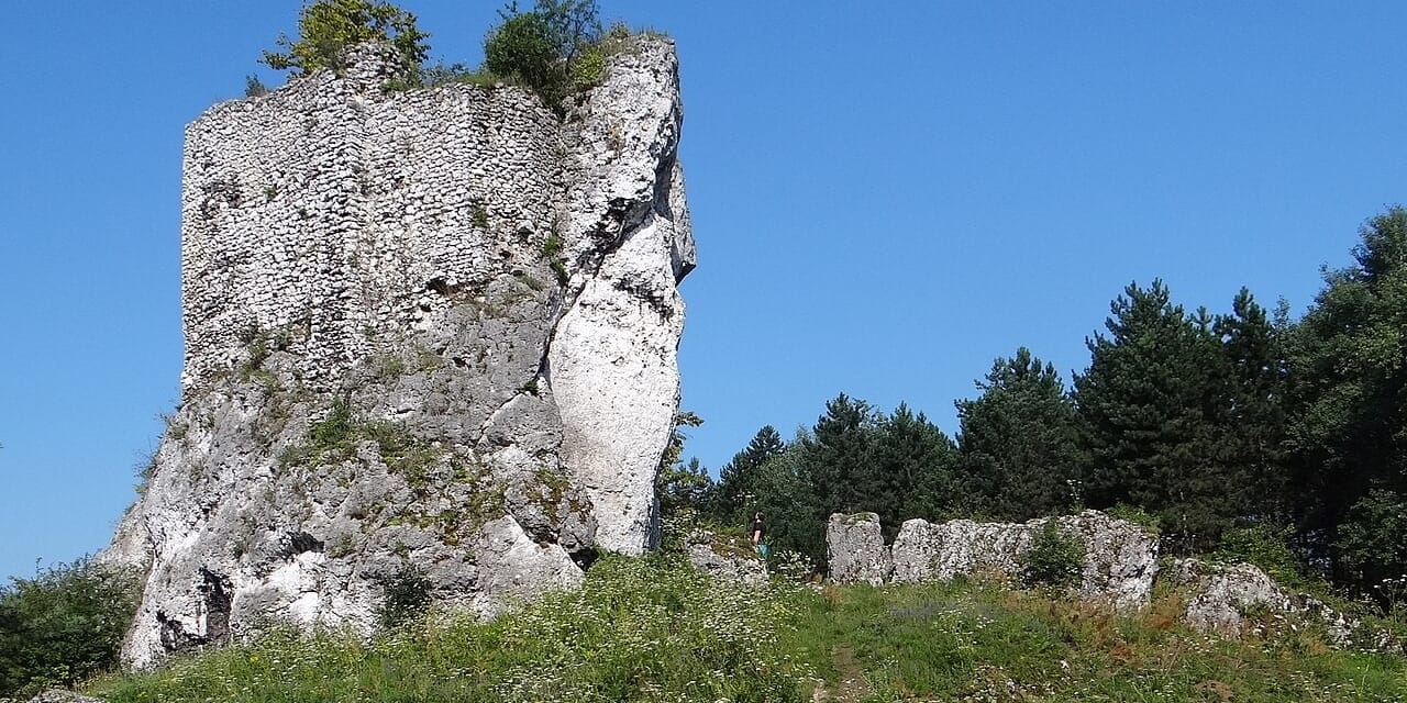 Skalny ostaniec z pozostałościami strażnicy w Przewodziszowicach, lipiec 2018. Fotografia archiwalna; piesza trasa prowadzi u podnóża.