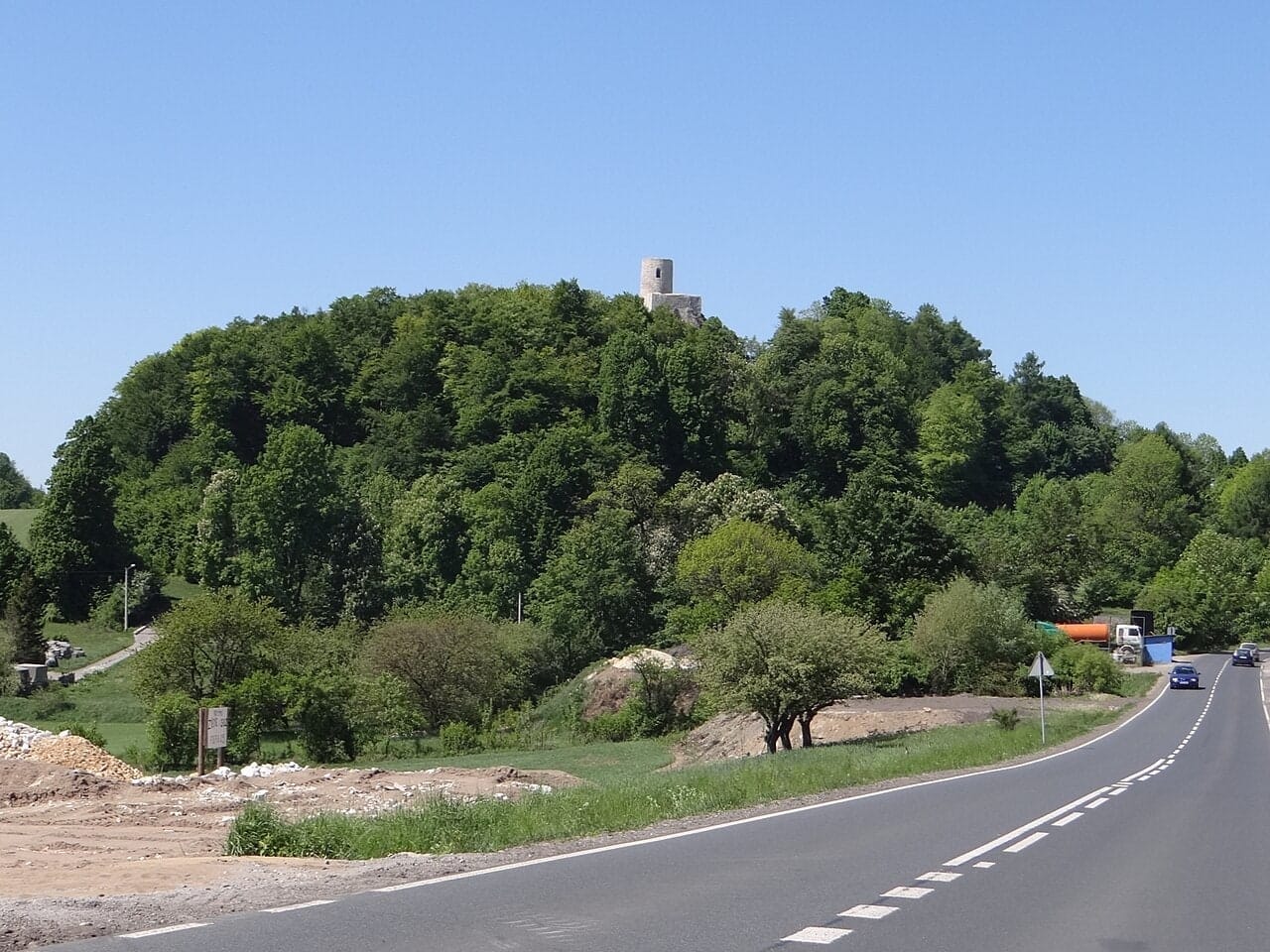 Zamek Pilcza ponad zalesionym wzgórzem w Smoleniu, widok z oddali. Fotografia archiwalna.