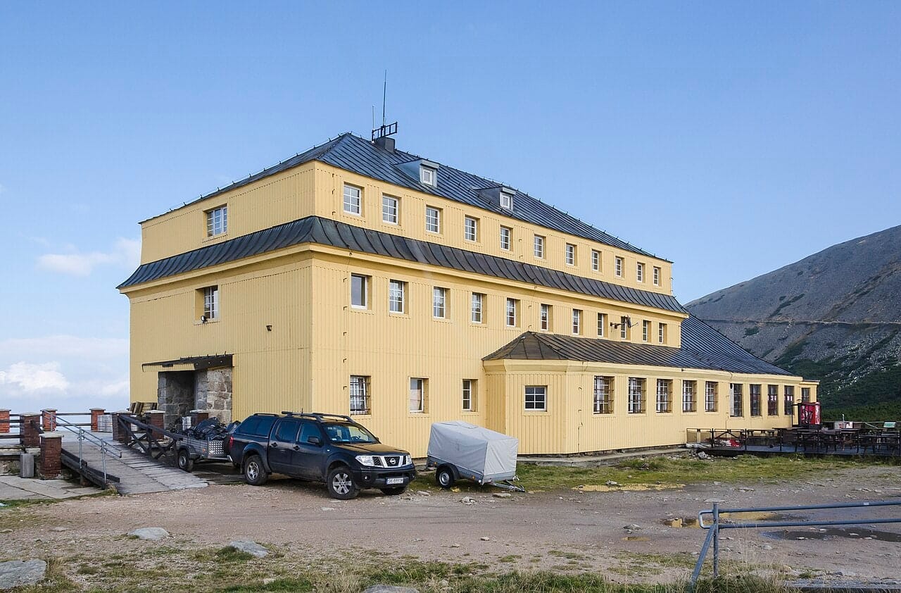 Żółty budynek schroniska Dom Śląski pod zboczem Śnieżki.