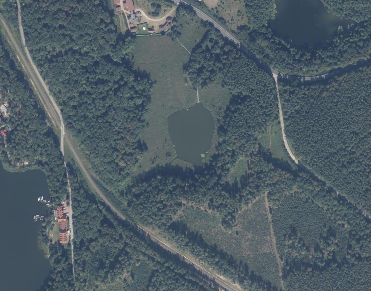Jezioro Chudek w Rucianem-Nidzie otoczone lasem — widok lotniczy